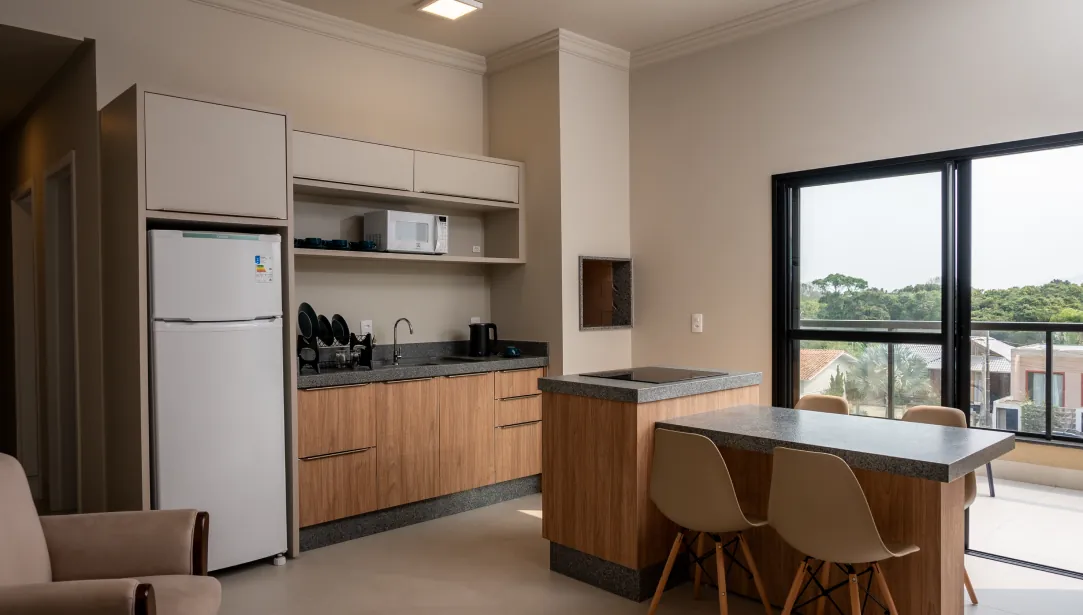 Cozinha integrada, equipada com eletrodomésticos modernos, móveis planejados e ampla iluminação natural.
