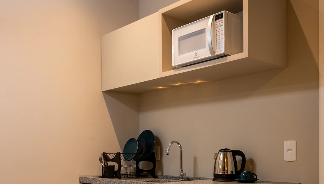 Cozinha integrada, equipada com eletrodomésticos modernos, móveis planejados e ampla iluminação natural.
