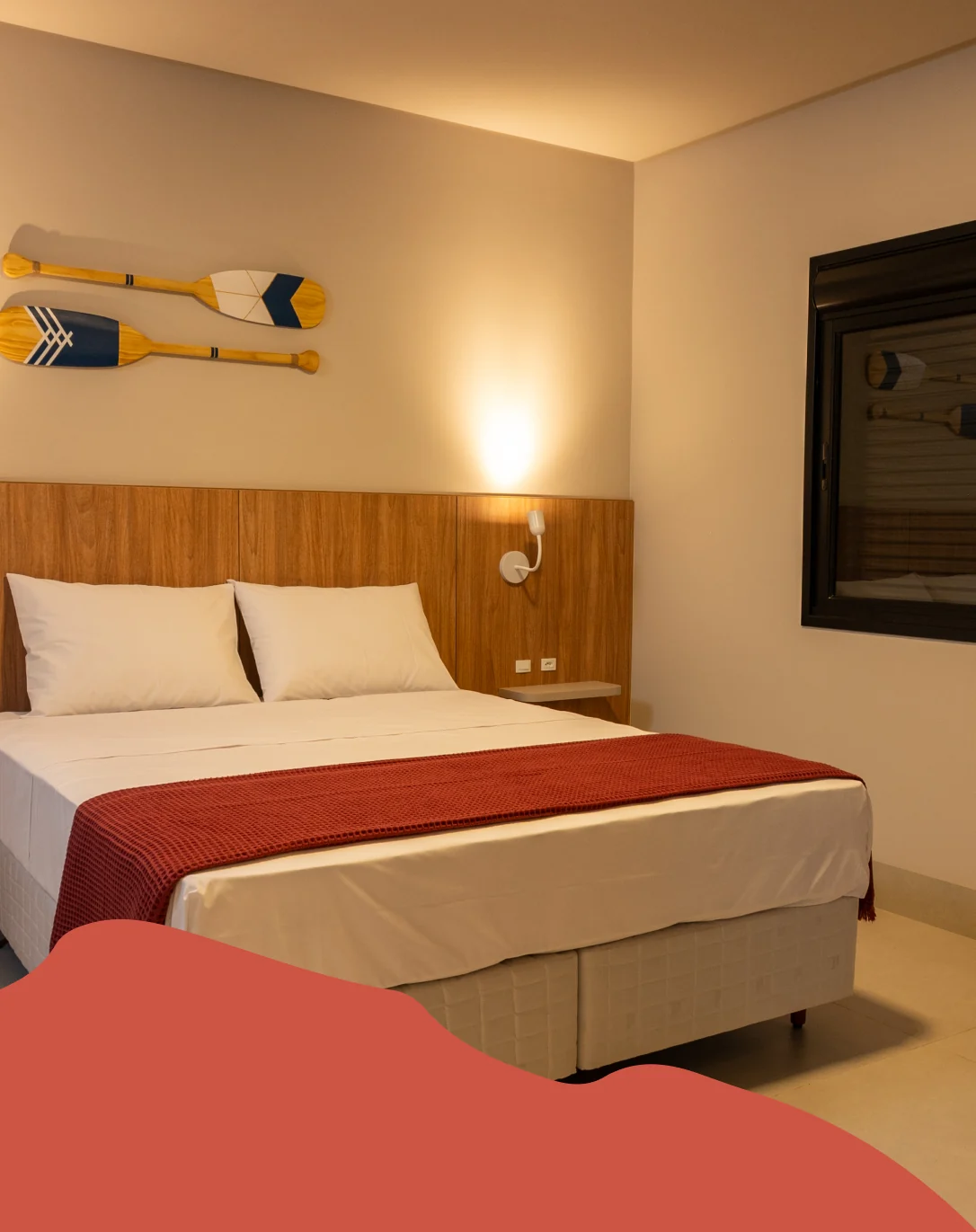 Quarto aconchegante com cama de casal, decoração de remos na parede e iluminação quente, ideal para relaxar em um ambiente acolhedor.