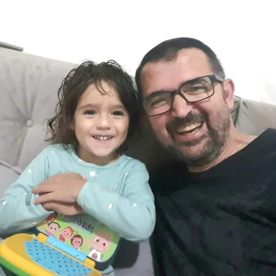 Pai e filha sorrindo felizes, refletindo a experiência incrível vivida na Pousada Caminho do Bosque.
